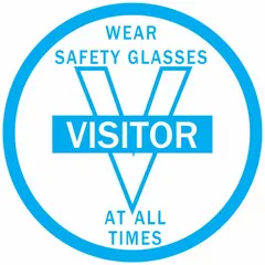 2-inch diameter non-reflective label for hard hats, printed in English with the message 'Wear Safety Glasses At All Times Visitor'. Supplied in a 4-pack for visitor PPE compliance in industrial environments.