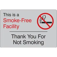 This adhesive-mounted sign is made of acrylic and measures 6 inches by 9 inches. It displays the message 'This Is A Smoke-Free Facility Thank You For Not Smoking' to communicate no-smoking policies. The sign is not retroreflective, not glow-in-the-dark, and has no anti-slip surface. Suitable for indoor use in workplaces, lobbies, break rooms, and other areas where smoking is prohibited.