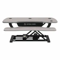 This electronic standing desk converter from VERSADESK features a gray wood desktop measuring 40 inches wide by 24 inches deep. It is designed to convert a standard desk into a sit-stand workstation, allowing users to alternate between sitting and standing positions. Suitable for office, home, and industrial environments to promote ergonomic health