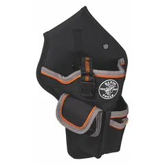 This nylon tool pouch features a black ballistic weave construction with four pockets and a snap closure. It attaches to a belt via a belt slot and is designed to carry cordless drills, providing organized storage for tools on a work belt.