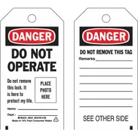 This lockout tag is made of polyester for resistance to moisture and chemicals in industrial environments. It features a write-on surface for adding specific remarks and is printed in English with a Danger Do Not Operate message. Used in lockout/tagout procedures to clearly communicate that equipment is undergoing maintenance and must not be operated