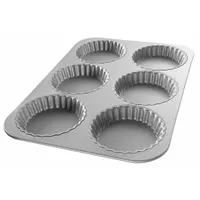 This fluted tart pan from CHICAGO METALLIC is made of aluminized steel with a shiny gray finish. It features 6 slots for baking individual tarts, quiches, or mini pies, with an overall width of 11 1/8 inches and depth of 7/8 inch. Suitable for commercial bakeries and foodservice operations requiring consistent portioning and presentation