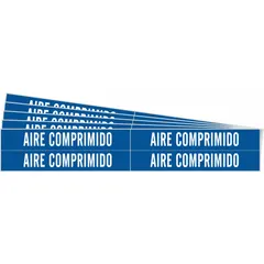 Blue fiberglass carrier-mounted pipe marker with white legend reading 'Aire Comprimido'. Designed for pipe outer diameters from 3/4 to 2-3/8 inches. Each pack contains 4 markers without arrows, supplied in a 5-pack. Used to identify compressed air lines in industrial piping systems.
