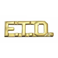 This metallic insignia is a rank designation for Field Training Officer, constructed from gold-toned metal. It measures 3/8 inch and attaches via a clutch pin. Typically worn on uniform collars or lapels in security and law enforcement settings. Sold as a single piece.