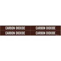 Brown adhesive pipe markers with white 'Carbon Dioxide' legend, designed for pipes with outer diameters from 3/4 to 2-3/8 inches. Each pack contains 4 markers without arrows, used to identify carbon dioxide piping in industrial and commercial facilities.