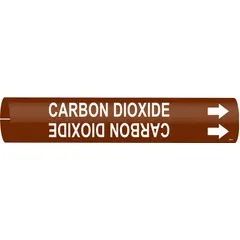This snap-on pipe marker identifies carbon dioxide lines in piping systems. It features a brown background with white legend text and includes directional arrows. Designed to fit pipe outer diameters from 1-1/2 to 2-3/8 inches. Supplied as a single marker.