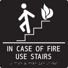 Adhesive sign with white/black background, nominal size 9 in x 9 in. Features Braille and visual text for emergency egress instructions. Designed for wall mounting in commercial buildings, hotels, and public facilities to indicate safe evacuation routes.