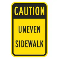 Aluminum caution sign warning of uneven sidewalk tripping hazards. Features Engineer Grade retroreflective material for low-light visibility and mounting holes for secure attachment to posts or walls. No anti-slip surface or glow-in-the-dark properties