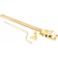 This non-handed window operator is designed for casement windows and mounts on the sash. It features a gold brass-plated finish and includes a crank handle for opening and closing the window. The base length is 3 3/16 inches.