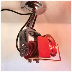 Red laser line projector with lens for alignment and positioning tasks. Operates on 110 V AC. Includes projector only.